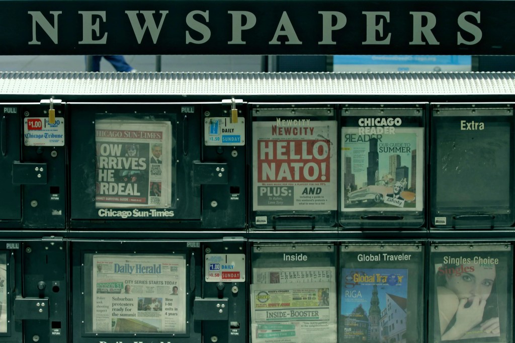 Image of a newspaper stand with a variety of newspapers for sale Image of a newspaper stand with a variety of newspapers for sale