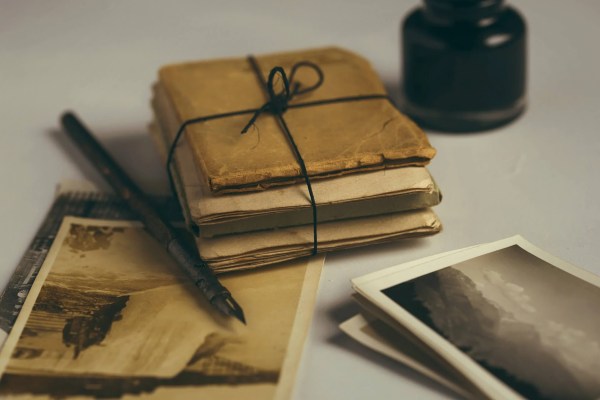 Shot of a quill, photographs and bundled papers
