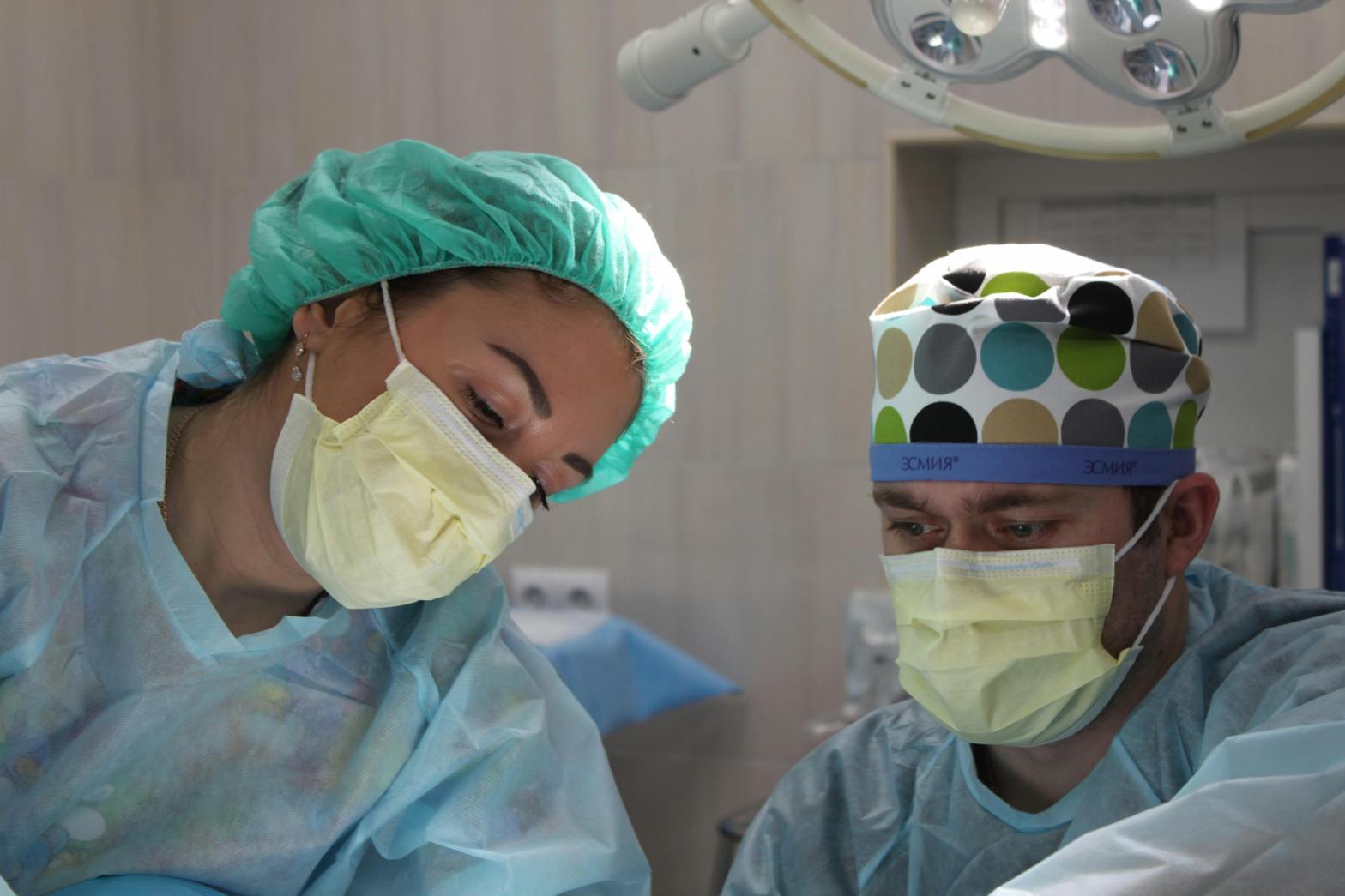 Doctors focus in operating room wearing masks and surgical protective gear