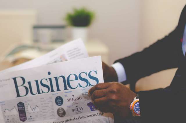 Man opening a business newspaper Man opening a business newspaper